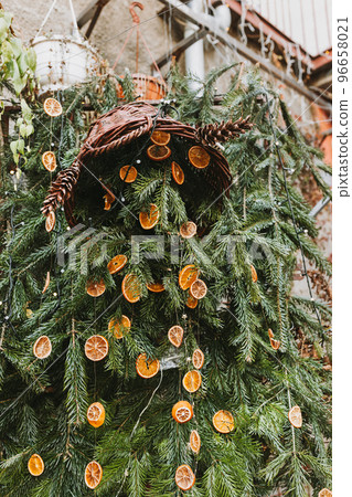 Natural decoration made of dry orange slices on pine branch. Diy Christmas food decoration. Environment, recycle, reuse and zero waste concept. Selective focus Natural decoration made of dry orange slices on pine branch. Diy Christmas food decoration. Environment, recycle, reuse and zero waste concept. Selective focus 96658021