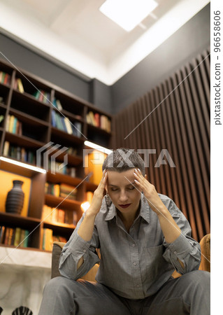 stylish caucasian woman holding her hands behind her head in thought 96658606