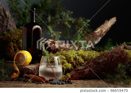 Gin-tonic cocktail with ice, lemon and a sprig of rosemary. 96659470