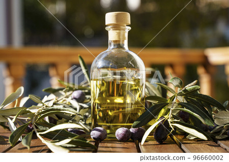 Olive oil with olive tree branch background. Natural oil for food or cosmetics from natural ingredients. Healthy food, cosmetics concept. 96660002