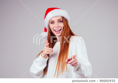 beautiful redhaired ginger woman wearing white knitted sweater and santa claus hat win concept studio background beautiful redhaired ginger woman wearing white knitted sweater and santa claus hat win concept studio background 96660450