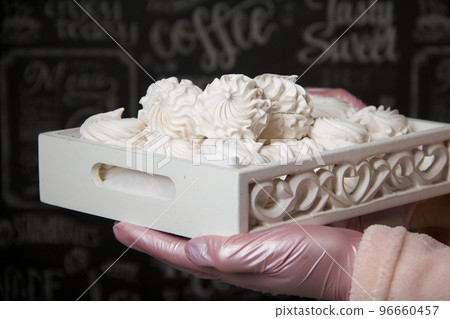 Homemade zephyr. A woman is holding a tray of marshmallows. Homemade zephyr. A woman is holding a tray of marshmallows. 96660457