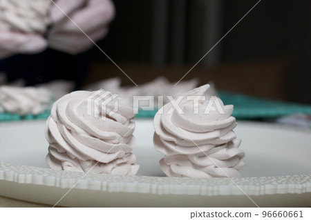 Homemade zephyr. White tray with marshmallows. Stands on black pine boards. Close-up. Homemade zephyr. White tray with marshmallows. Stands on black pine boards. Close-up. 96660661