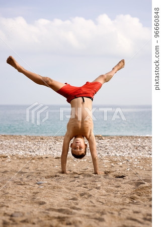 kid does acrobatics on the beach kid does acrobatics on the beach 96660848