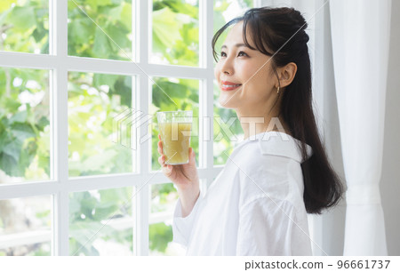 A woman drinking vegetable juice 96661737