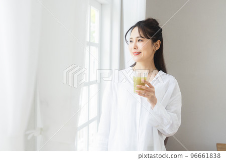 A woman drinking vegetable juice 96661838