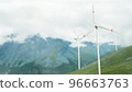 Wind turbines on a mountain pass, renewable energy. Clouds are floating, a hazy haze. Snow. The concept of renewable energy sources. 96663763
