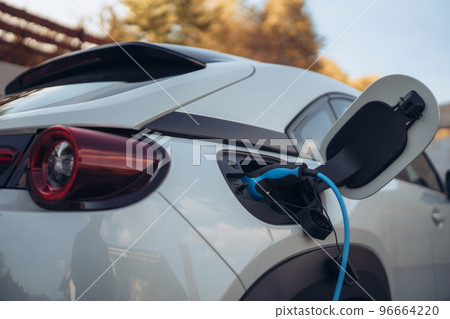 Charging an electric car in home,sustainable transportation concept. 96664220