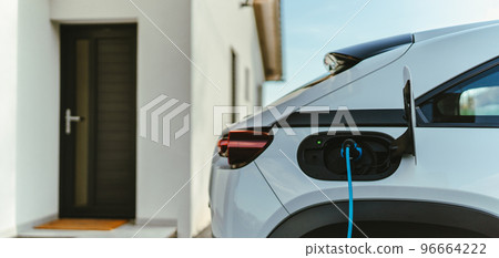 Charging an electric car in home,sustainable transportation concept. 96664222