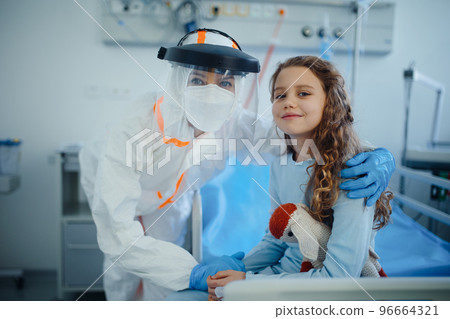 Portrait of healed child with doctor at isolation ward in hospital. 96664321