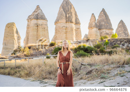 Woman tourist on background of Unique geological formations in Love Valley in Cappadocia, popular travel destination in Turkey Woman tourist on background of Unique geological formations in Love Valley in Cappadocia, popular travel destination in Turkey 96664876