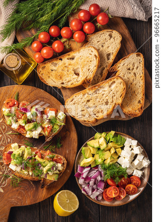 Tasty and healthy avocado, cherry tomatoes and feta cheese sandwiches. Toasts  with avocado, tomatoes and feta cheese. 96665217