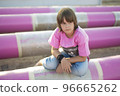Cute caucasian boy posing in a pink stylish printed t-shirt among pink iron pipes on an industrial background. Fashion style photoshoot 96665262
