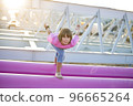 Cute caucasian boy posing in a pink stylish printed t-shirt among pink iron pipes on an industrial background. Fashion style photoshoot 96665264