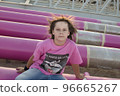 Cute caucasian boy posing in a pink stylish printed t-shirt among pink iron pipes on an industrial background. Fashion style photoshoot 96665267