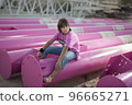 Cute caucasian boy posing in a pink stylish printed t-shirt among pink iron pipes on an industrial background. Fashion style photoshoot 96665271