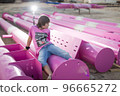 Cute caucasian boy posing in a pink stylish printed t-shirt among pink iron pipes on an industrial background. Fashion style photoshoot 96665272