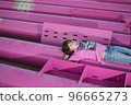 Cute caucasian boy posing in a pink stylish printed t-shirt among pink iron pipes on an industrial background. Fashion style photoshoot 96665273