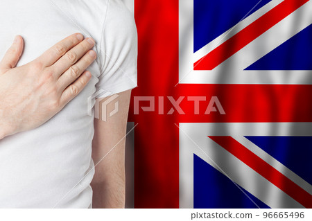 English person with hand on heart on the background of UK flag.  96665496