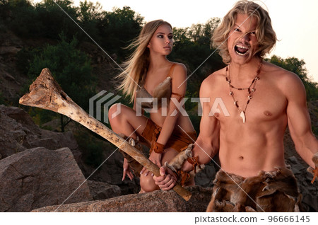 Primitive sexy man posing with his beautiful wild woman among rocks and nature 96666145