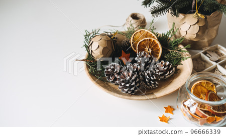 Natural Eco friendly Christmas Tree Decorations. Zero waste sustainable Xmas Tree Ornament Hanging Decorations. Christmas Tree and dry orange Slices, snow Christmas Pine Cones Ornament on table 96666339