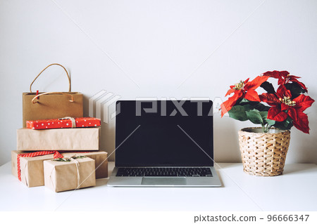 Blank display screen laptop computer with Poinsettias Christmas Flower and gift boxes on white table. Home office desk workspace with Mock up copy space. Christmas online shopping, Winter sales, Blank display screen laptop computer with Poinsettias Christmas Flower and gift boxes on white table. Home office desk workspace with Mock up copy space. Christmas online shopping, Winter sales, 96666347