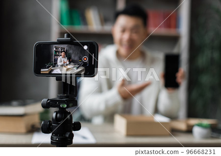 Focus on screen of smartphone, pleasant asian man filming video on modern phone camera Focus on screen of smartphone, pleasant asian man filming video on modern phone camera 96668231
