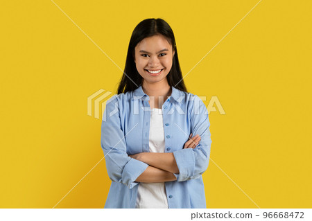 New style and success. Happy confident millennial korean lady student in casual with crossed arms look at camera New style and success. Happy confident millennial korean lady student in casual with crossed arms look at camera 96668472