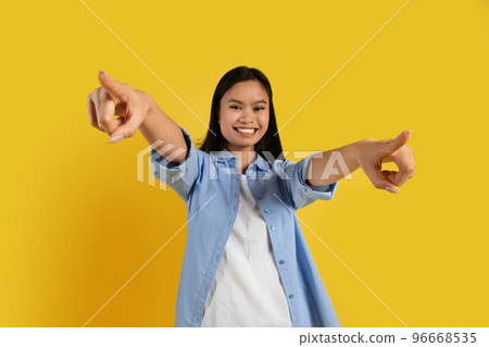 Glad confident millennial chinese lady student in casual point fingers at camera, has fun 96668535