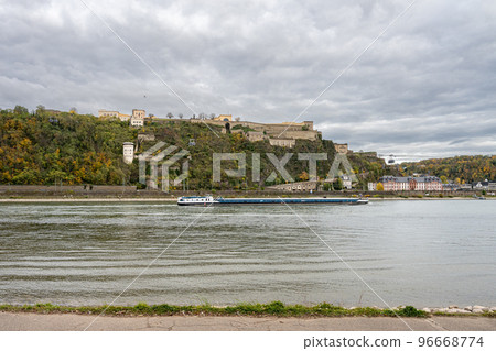 German corner, Koblenz were Rhein and Mosel meet. A river barge in the foreground with the fortress Ehrenbreitstein in the background 96668774
