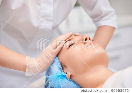 woman receiving facial massage at spa salon woman receiving facial massage at spa salon 96668975