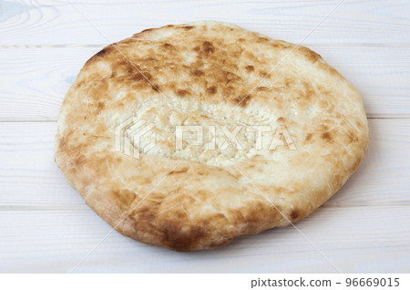 Wheat tortilla with sesame seeds on white wooden table. 96669015