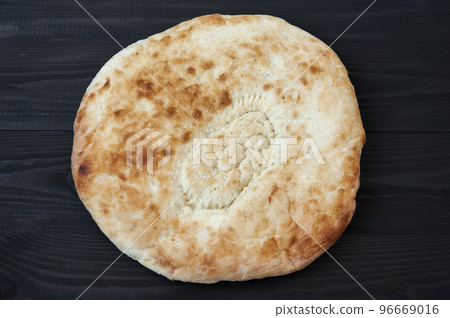 Wheat tortilla with sesame seeds on black wooden table. 96669016