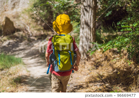 Boy tourist exploring valley with rock formations and fairy caves near Goreme in Cappadocia Turkey 96669477