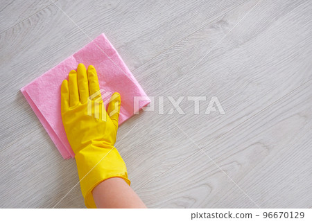 Cleaning concept in office, home. Female hand with pink rag is wipes light wooden floor at home. Housework and housekeeping concept. Cleaning concept in office, home. Female hand with pink rag is wipes light wooden floor at home. Housework and housekeeping concept. 96670129