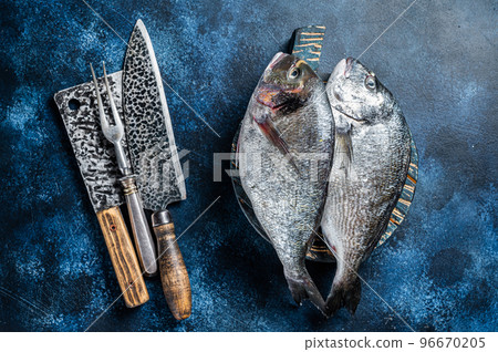 Sea bream or dorado fish on fish market cutting board. Blue background. Top view 96670205