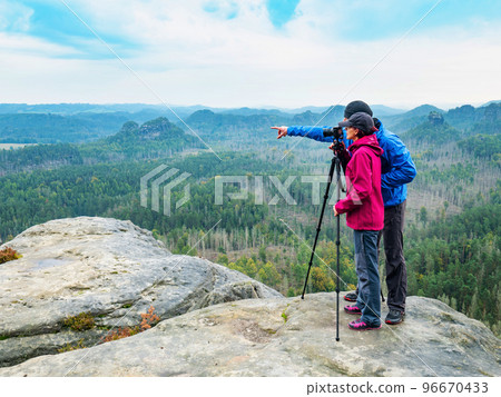 Man and woman photographers  shooting sunset on the top mountain. 96670433