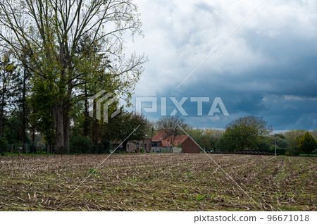 Harvested soil of agriculture fields with dark rainy clouds in the background, Zellik, Belgium 96671018