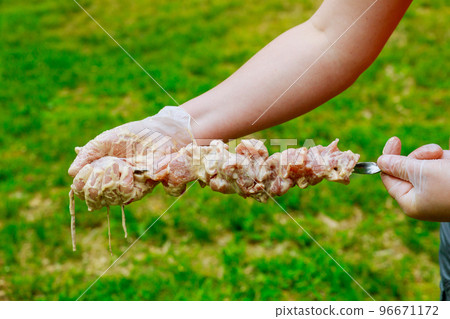 Raw pork skewers in marinade with tasty grilled kebab Raw pork skewers in marinade with tasty grilled kebab 96671172