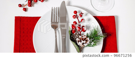 Christmas table setting. Plate and cutlery on red napkin. Decoration for festive dinner. Christmas table setting. Plate and cutlery on red napkin. Decoration for festive dinner. 96671256