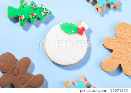 Christmas cookies shape of ball, gingerbread man and candy cane form on the blue background, top view, flat lay Christmas cookies shape of ball, gingerbread man and candy cane form on the blue background, top view, flat lay 96671265