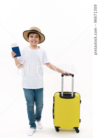 Full size of a teenage boy in casual t-shirt, jeans and straw hat, walking with boarding pass and yellow suitcase on white background. Travel destinations, journey, air trip concepts. Free ad space Full size of a teenage boy in casual t-shirt, jeans and straw hat, walking with boarding pass and yellow suitcase on white background. Travel destinations, journey, air trip concepts. Free ad space 96671309