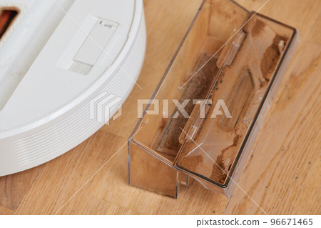 Cleaning the filter of the vacuum robot cleaner from dirt, close-up. Cleaning the filter of the vacuum robot cleaner from dirt, close-up. 96671465