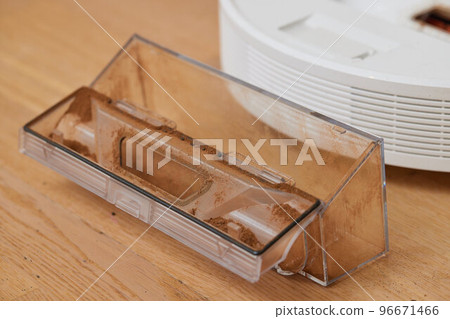 Cleaning the filter of the vacuum robot cleaner from dirt, close-up. Cleaning the filter of the vacuum robot cleaner from dirt, close-up. 96671466