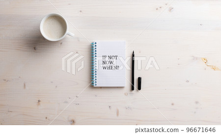 Top view of a spiral notepad with an If not now when sign written in it 96671646