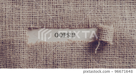 Rough linen fabric with a torn window in the middle with an OOPS!! sign written in it Rough linen fabric with a torn window in the middle with an OOPS!! sign written in it 96671648