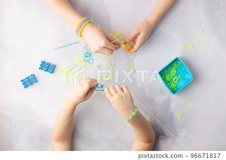 Concept of making loom bracelets by kids blue and yellow 96671817