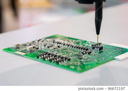 Automatic manipulator with dispenser needle during work with SMT pcb - close up Automatic manipulator with dispenser needle during work with SMT pcb - close up 96672197