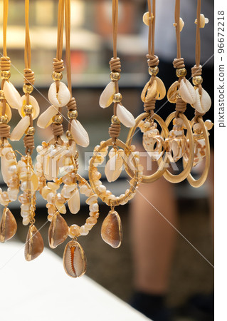 Jewelery showcase sea decorations on street market. Woman choosing decorations on local street market in Gdansk, Poland. Female tourist is choosing souvenirs in street shop and looking at color Jewelery showcase sea decorations on street market. Woman choosing decorations on local street market in Gdansk, Poland. Female tourist is choosing souvenirs in street shop and looking at color 96672218