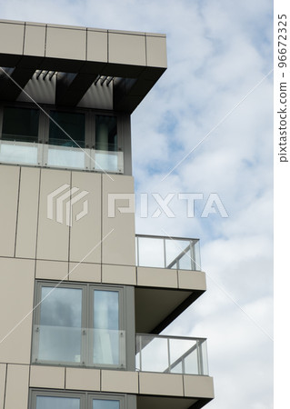 Modern office building exterior with glass facade on clear sky background. Transparent glass wall of office building with yellow decoration. Element of facade of modern European building Commercial 96672325